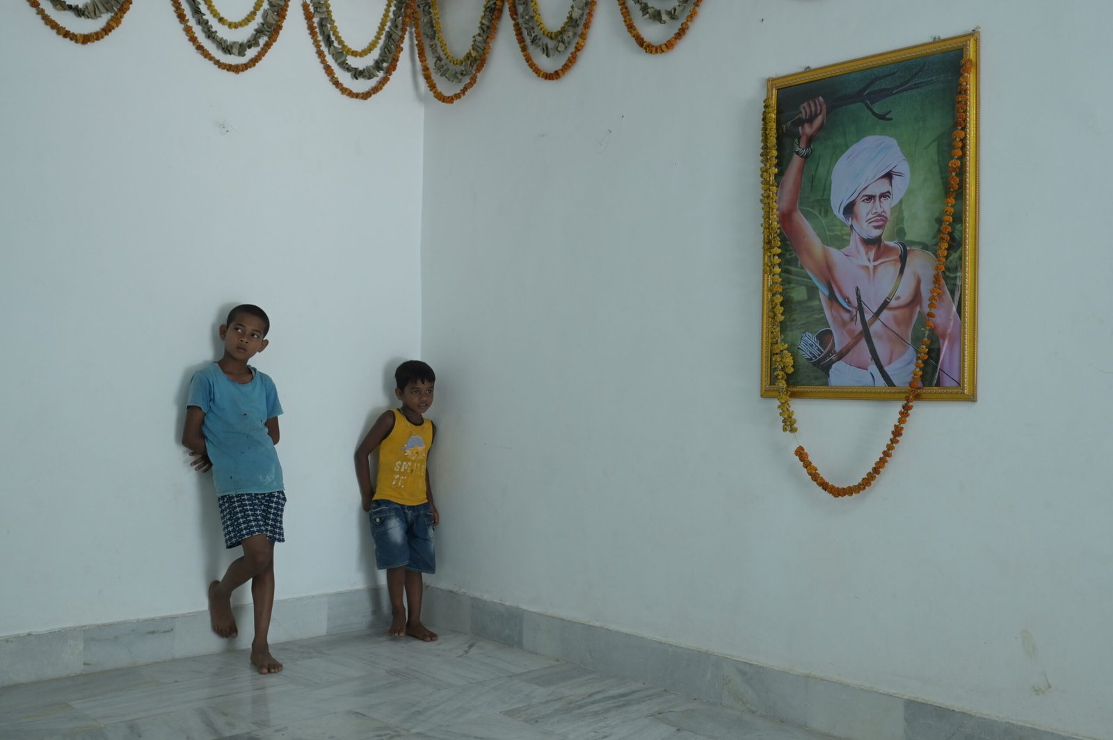 The grandsons of Sukhram Munda stand beside a portrait of Birsa Munda at
his birthplace.